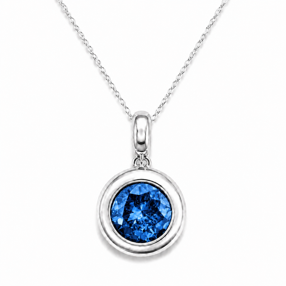 A silver pendant necklace featuring a round bezel-set blue gemstone, suspended from a delicate silver chain against a clean white background.