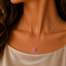 Load image into Gallery viewer, Pink Sapphire and Diamond 18ct White Gold pendant on lady's neck.  She wears a  soft satin scoop top.  The pendant is round with a square of 9 pink saphires in the middle and the outside filled in with 16 smaller diamonds.  It is shown on a white gold chain which can be purchased separately.
