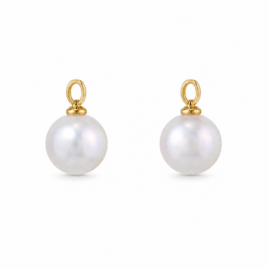 A pair of gold ear charms featuring a single round white pearl drop on each, set against a plain white background.