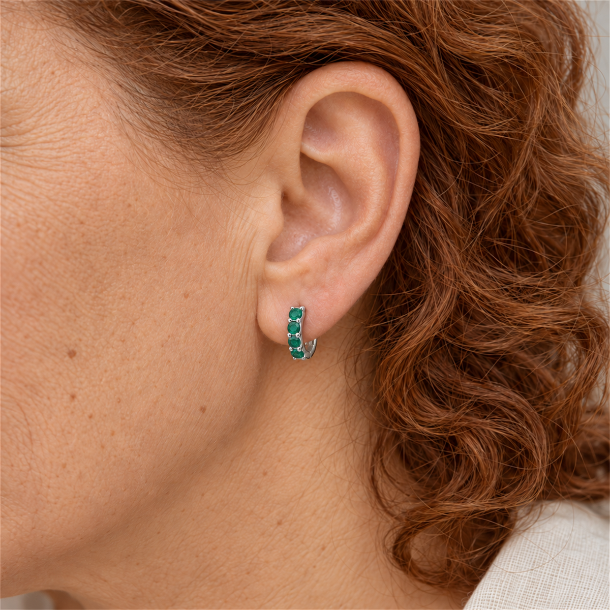 Sterling Silver emerald colour cubic zirconia huggie with four stones worn by Urban Armour model