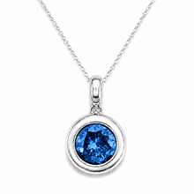 Load image into Gallery viewer, A silver pendant necklace featuring a round bezel-set blue gemstone, suspended from a delicate silver chain against a clean white background.

