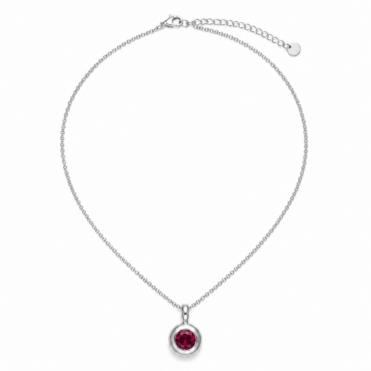 A silver chain necklace with a circular bezel setting holding a round, deep red gemstone, displayed on a clean white background.