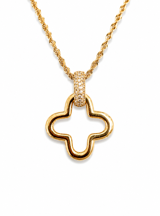 A gold necklace featuring an open quatrefoil pendant with a pavé-set accent at the top, displayed on a clean white background.